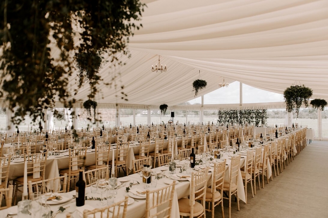 12 meter Time Marquees wedding tent with decorated trestle tables, chairs, plants hanging